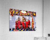 Monks in red robes gathered around a golden statue. Acrylic Print
