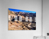 Hikers traverse a vast arid rocky desert landscape. Acrylic Print