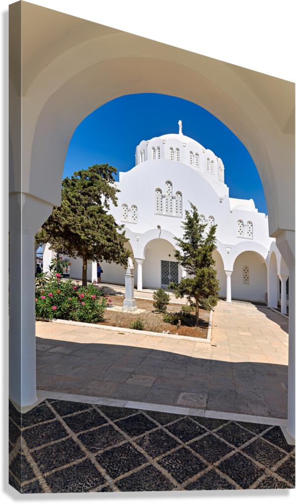 White domed church through an archway in Greece.