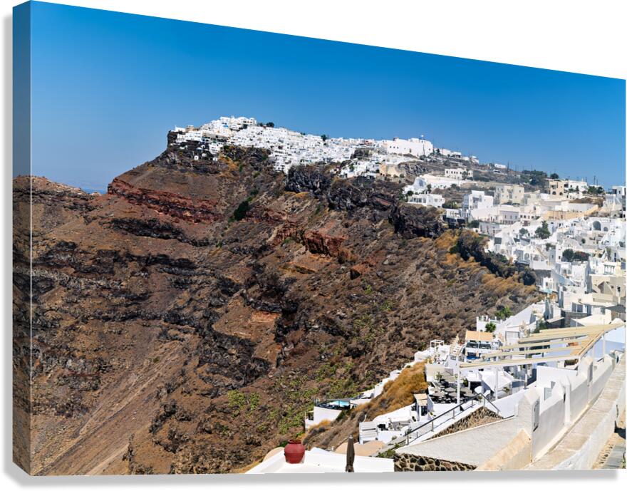 Santorinis white village on volcanic cliff.