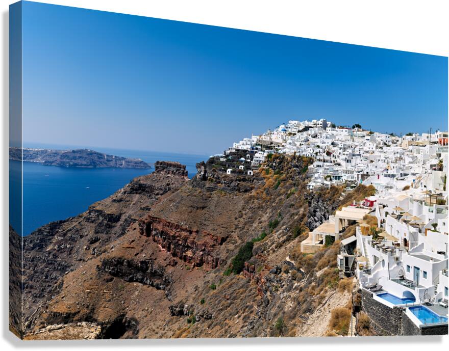 Santorini village on cliff overlooking caldera and sea.