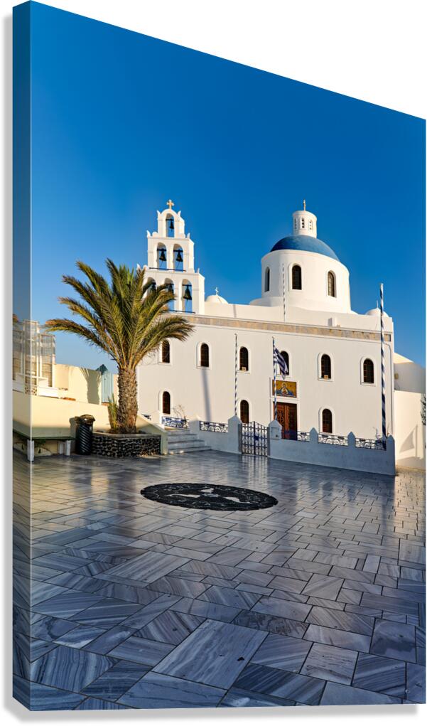 White Greek church with blue dome and palm tree under clear sky.