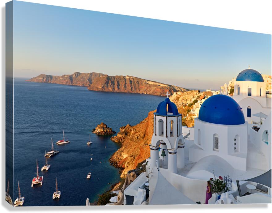 Santorinis beautiful blue domed churches caldera and sea.