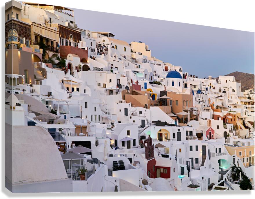 Santorinis iconic white buildings and blue domes on a hillside.