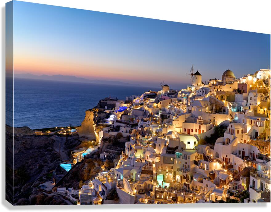 Santorinis Oia village illuminated at dusk overlooking the se