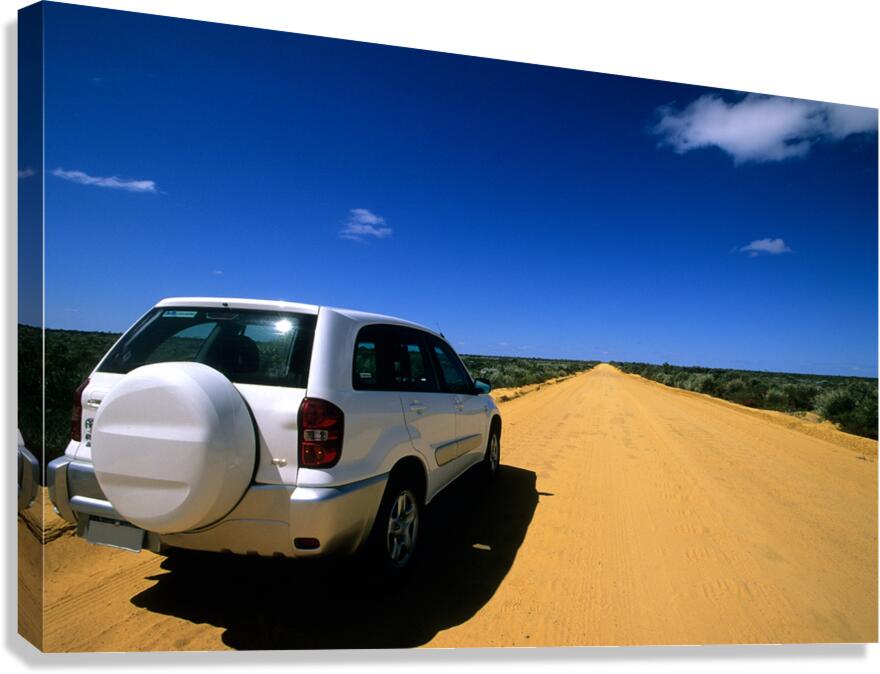 A white SUV on a long straight outback road.