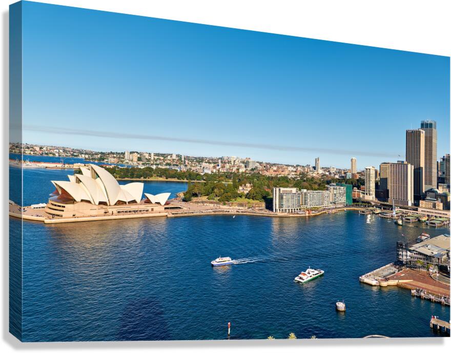 Sydney Opera House and harbor with ferries on a sunny day.