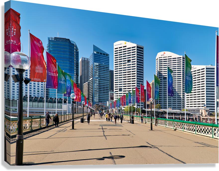 Darling Harbour promenade with flags and city skyline.