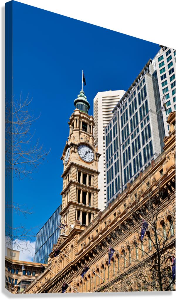 Historic clock tower stands tall against modern buildings.
