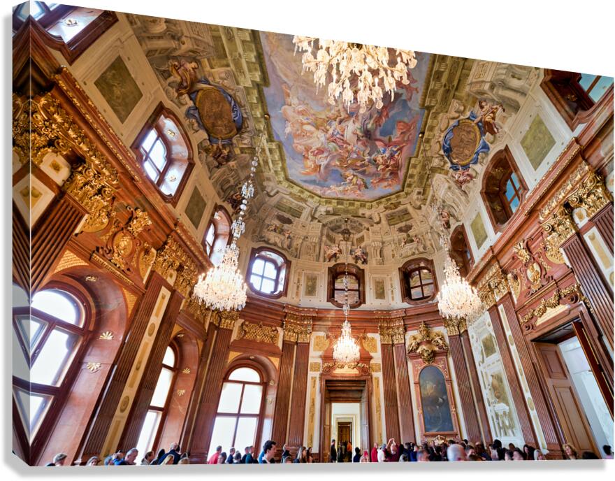 Ornate baroque hall with painted ceiling and chandeliers.