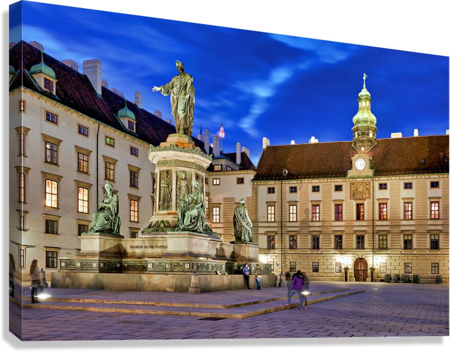 Monument in illuminated Hofburg courtyard Vienna at night.