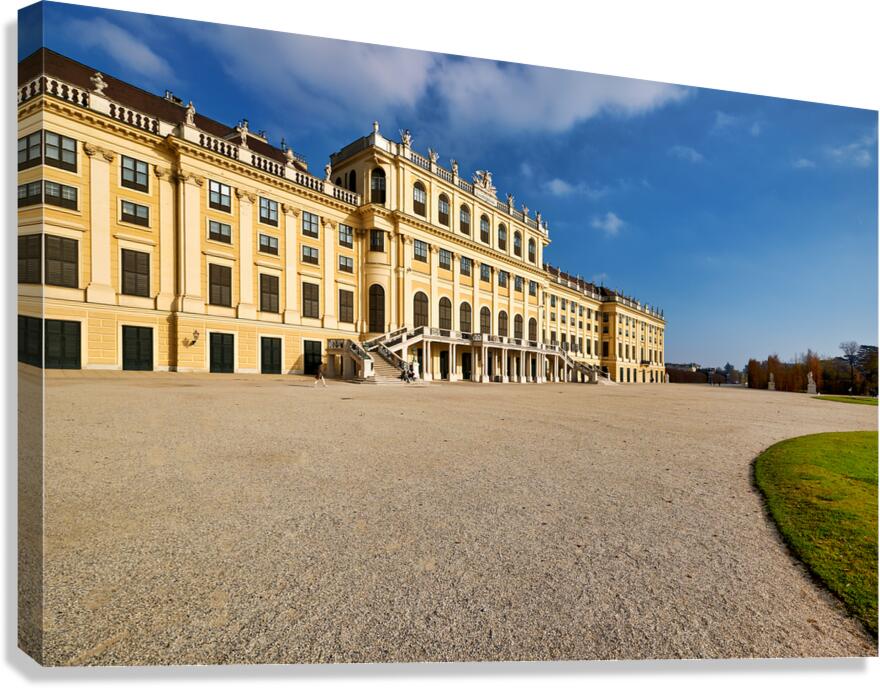Majestic yellow palace gravel courtyard blue sky.