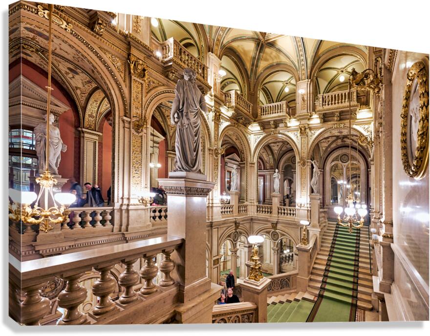 Luxurious opera house interior with grand staircase and statues.