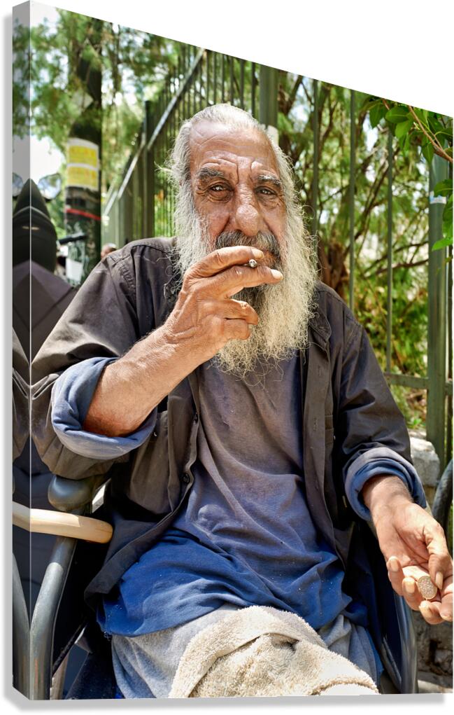 Man sitting outdoors while smoking a cigarette in the city