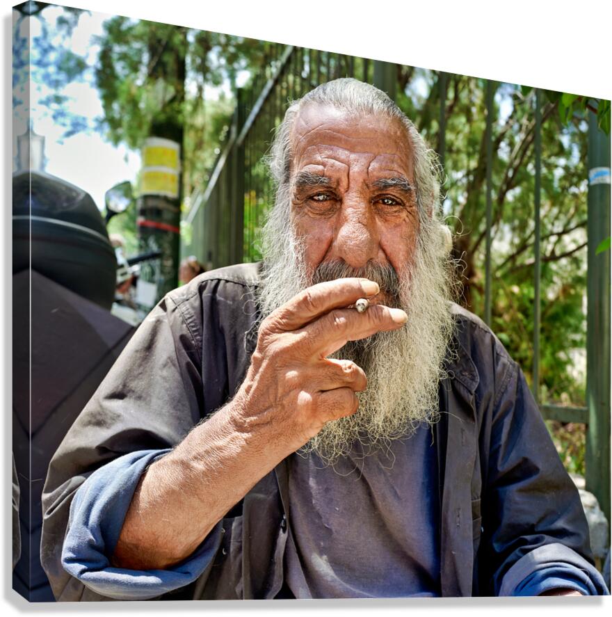Man sitting outside with a cigarette and a beard