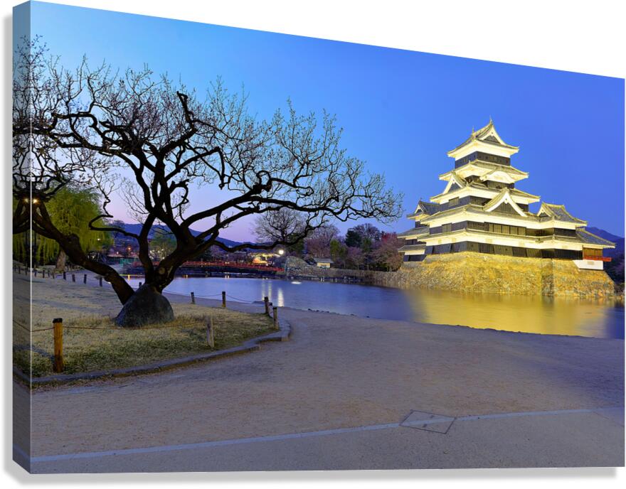 Matsumoto Castle stands by a river at sunset in Japan