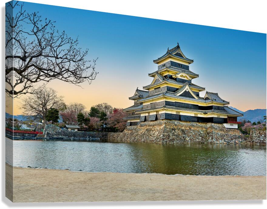 Matsumoto Castle standing by water during sunset in Japan