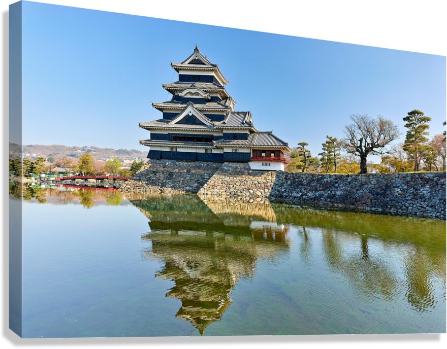 Matsumoto Castle reflects in the water on a clear day in Japan