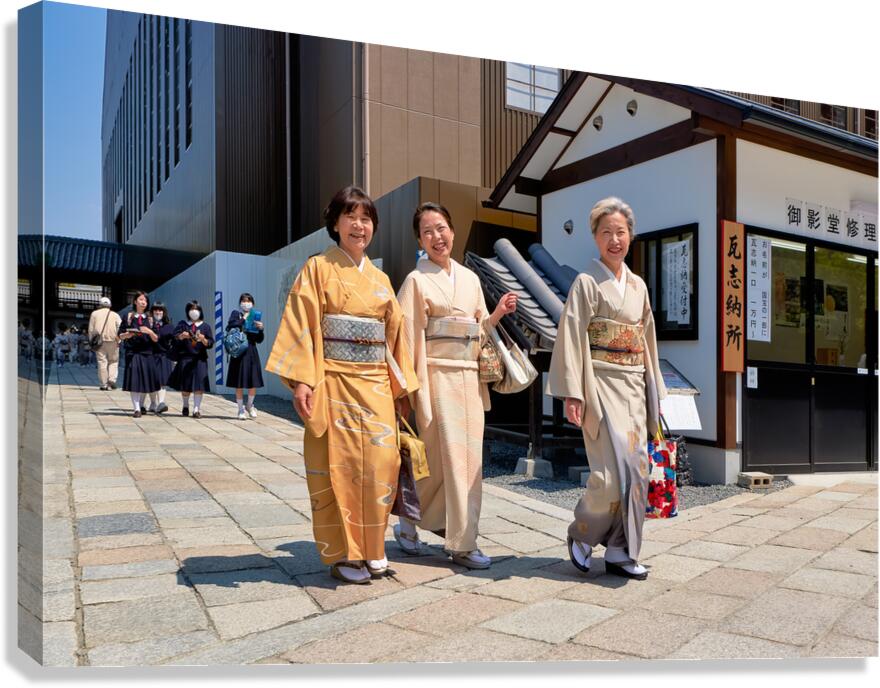 Smiling women in kimono walk through Kyoto streets during daytim