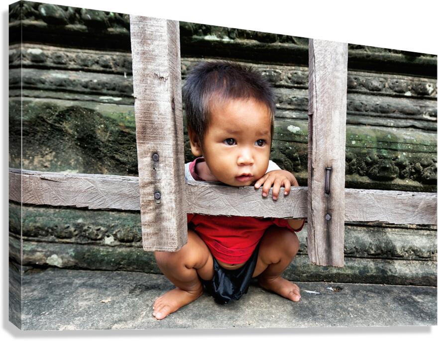 Curious child peeking through wooden frame at ancient ruins.