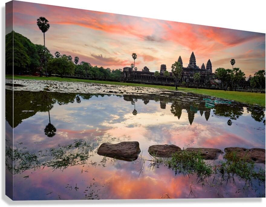 Angkor Wat temple reflected in water at sunset.