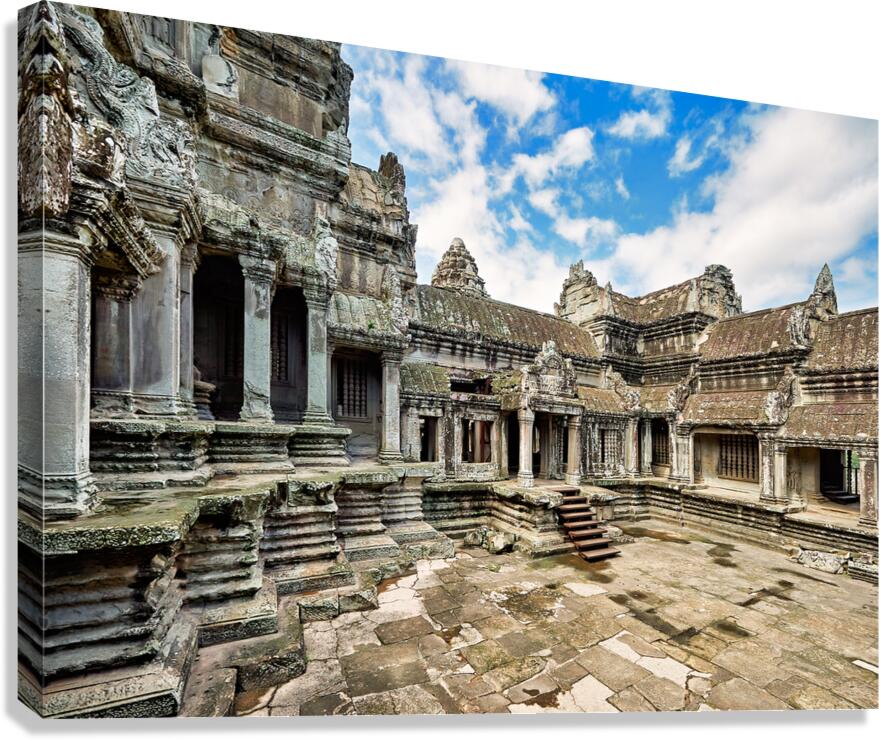 Ancient Angkor Wat temple complex under a blue sky.