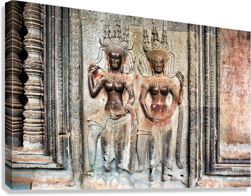 Two ornate Apsara carvings on an ancient temple wall.