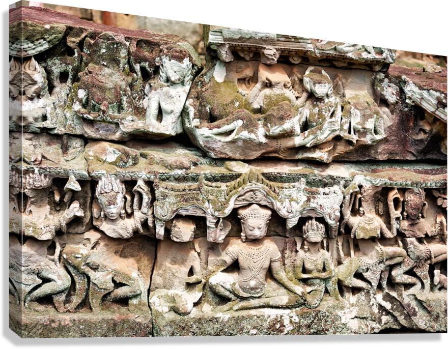 Intricate ancient stone carvings on a moss covered temple.