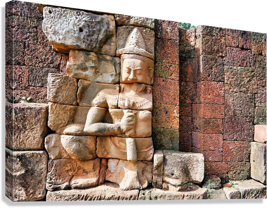 Ancient Khmer stone carving on a weathered temple wall.
