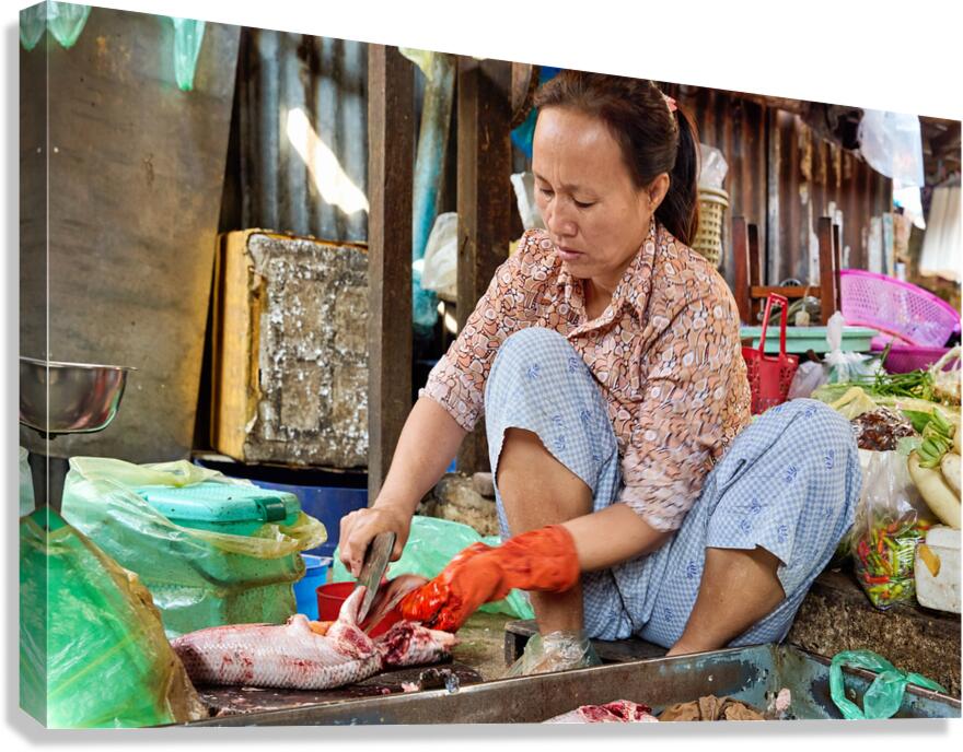 Market woman cleaning fish.