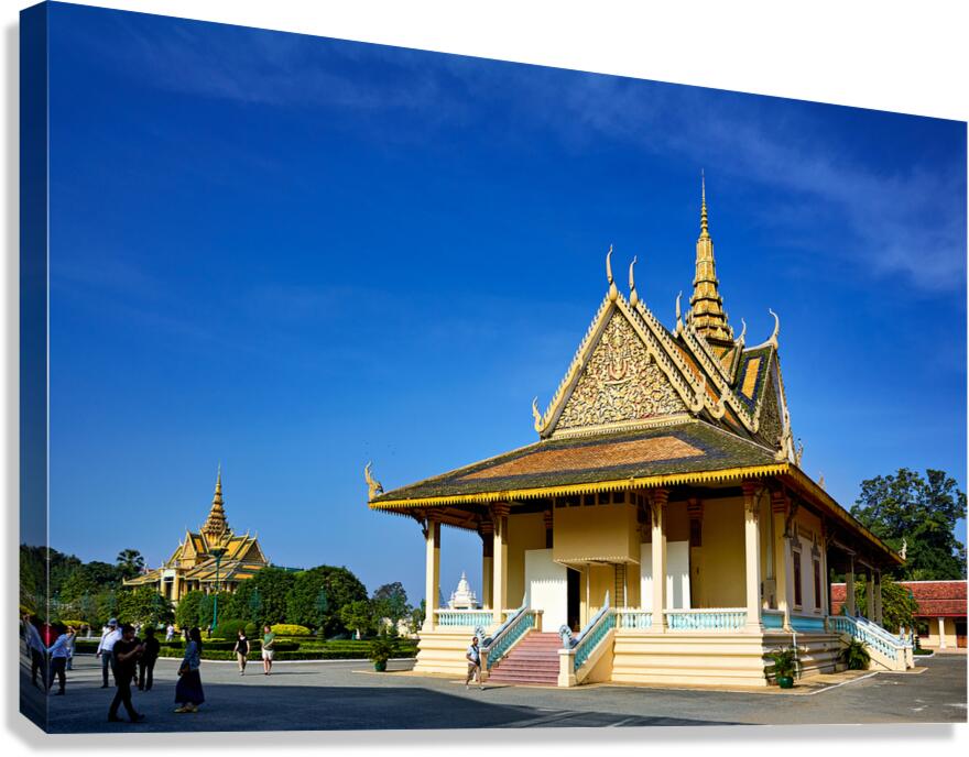 Ornate Cambodian temple under clear blue sky with visitors.