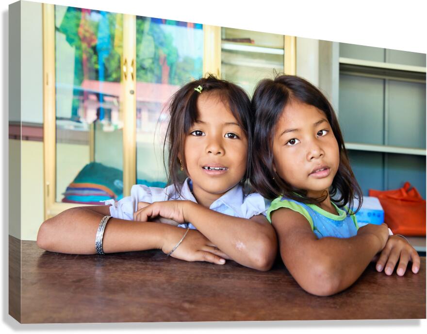 Two young girls pose together looking at the camera.