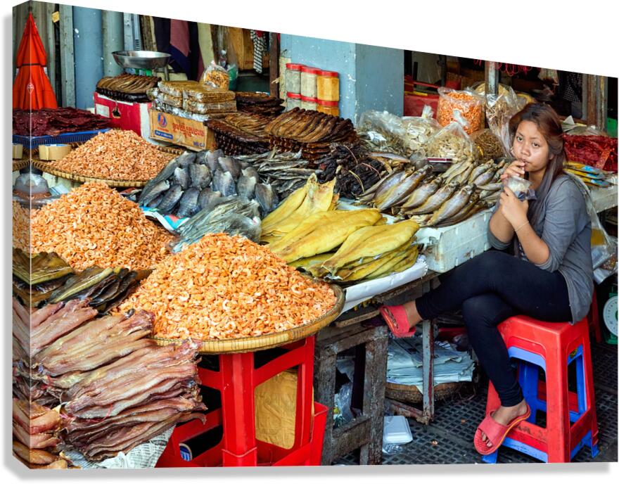 Woman selling dried seafood and shrimp at market.