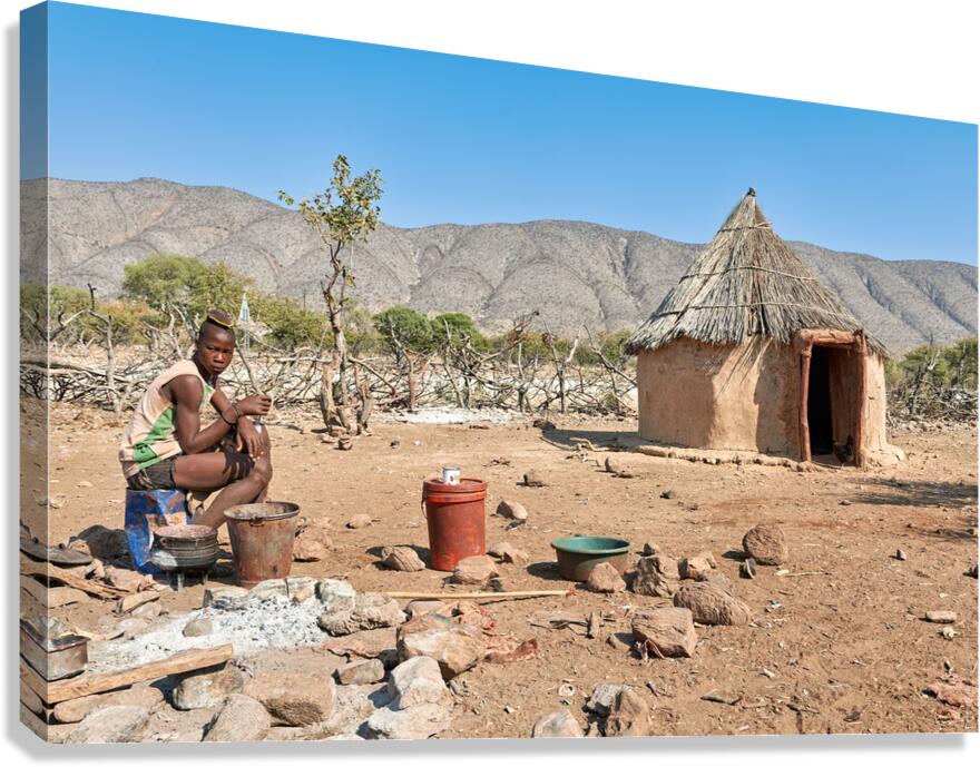 Young man near hut in Himba village in Kunene region of Namibia