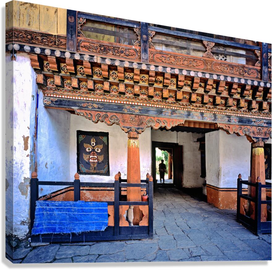 Intricate Bhutanese temple entrance with a person and fierce mas