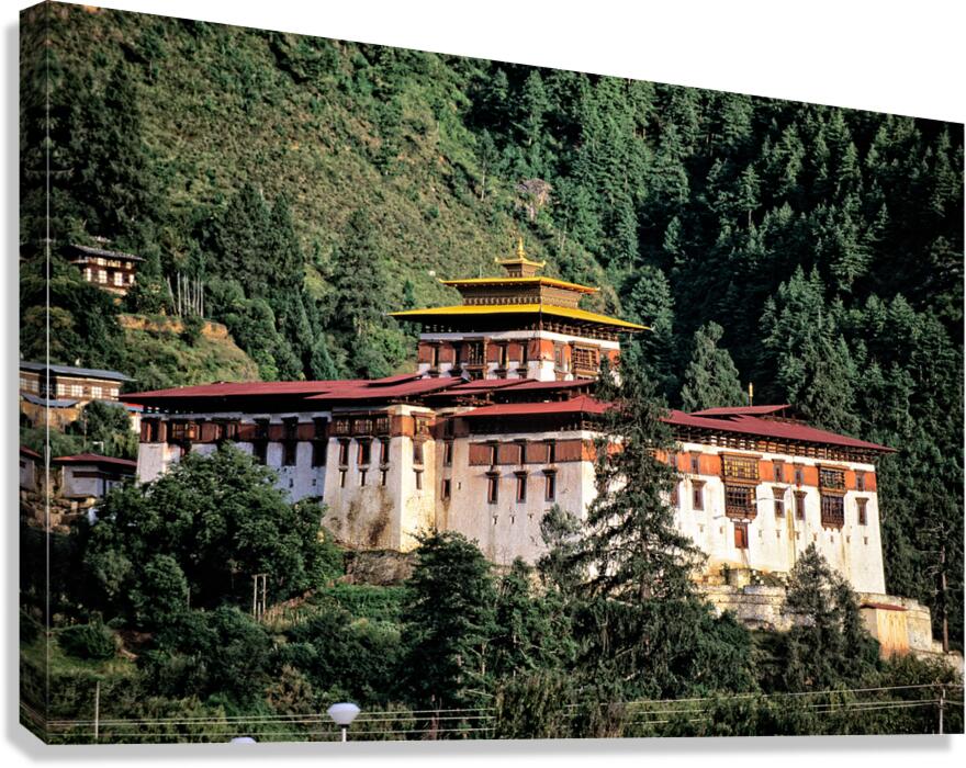 Majestic Bhutanese dzong amidst dense green forest.