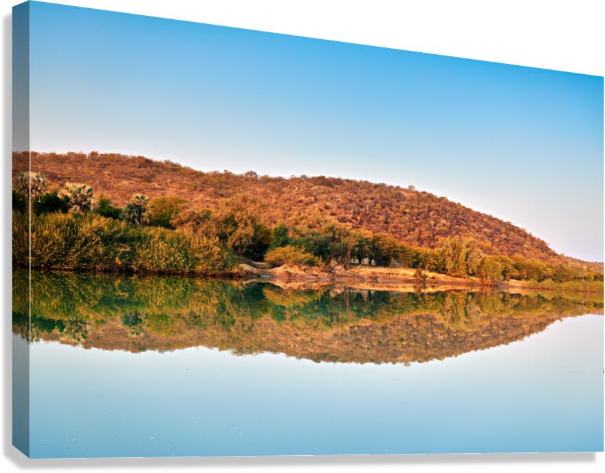 Okavango river reflects dusk sky in Kavango region of Namibia