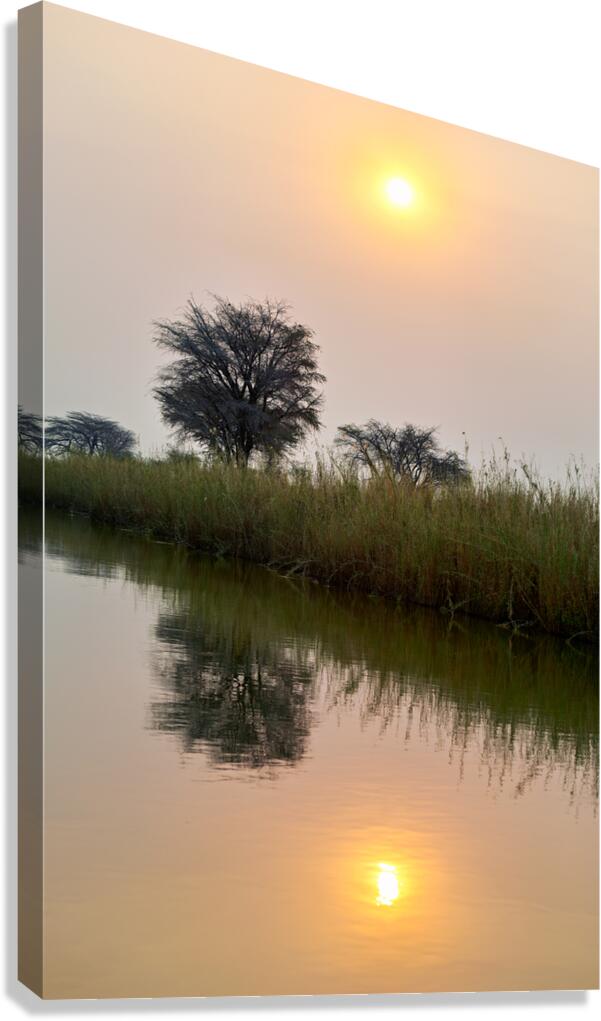 Banks of Okavango River at dusk in Namibia with reflections