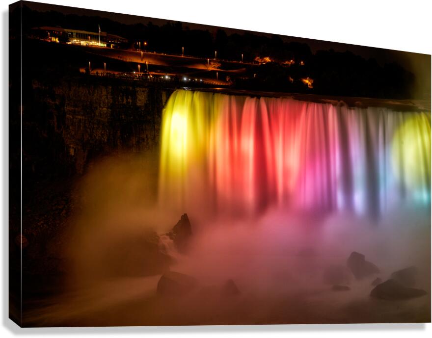 Niagara Falls illuminated at night with vibrant colors.