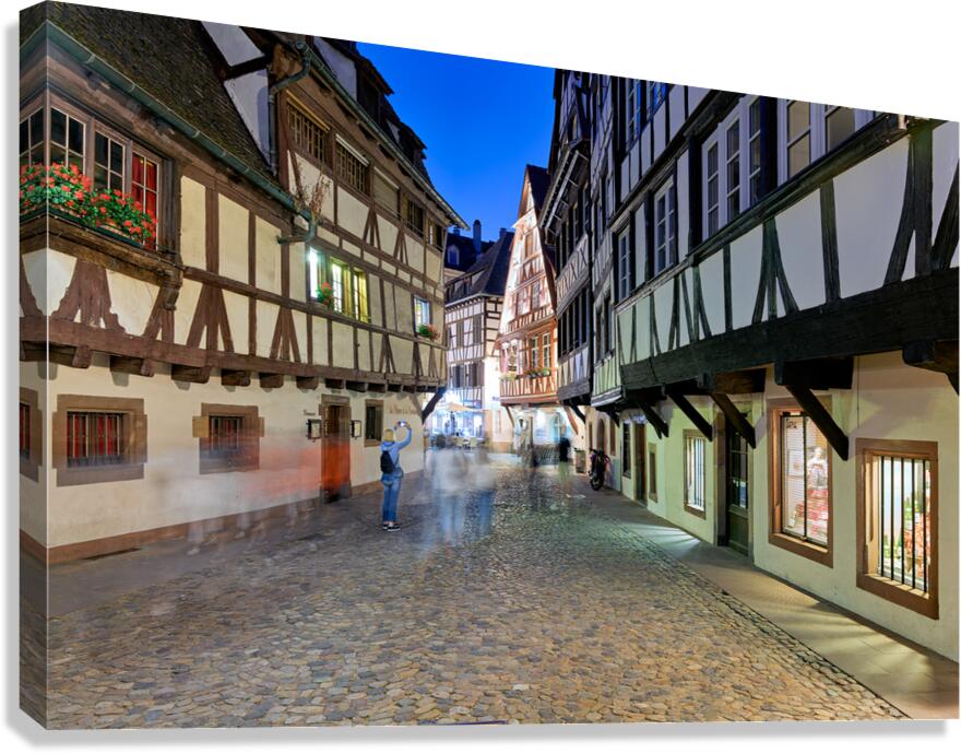 People walk in Petit France district of Strasbourg at dusk