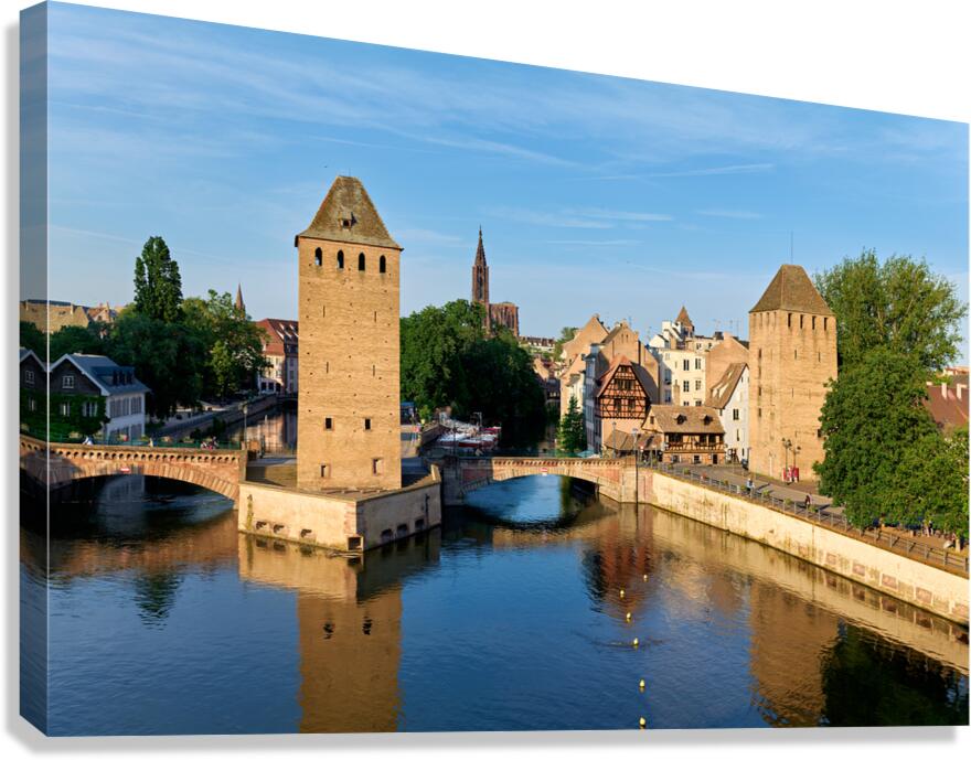 Covered bridges and towers in Strasbourg at sunset over water