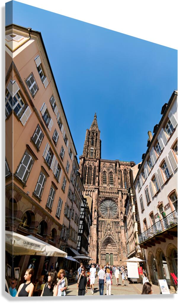 Visitors stroll by the Cathedral in sunny Strasbourg