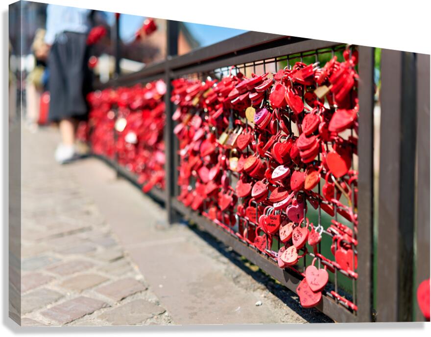 Visitors add red padlocks to a fence in Petite Venise Colmar