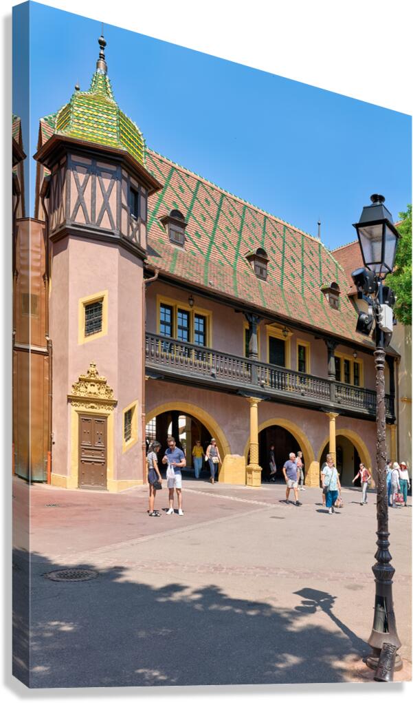 Visitors walk near the historic Koifhus house in Colmar on a sun