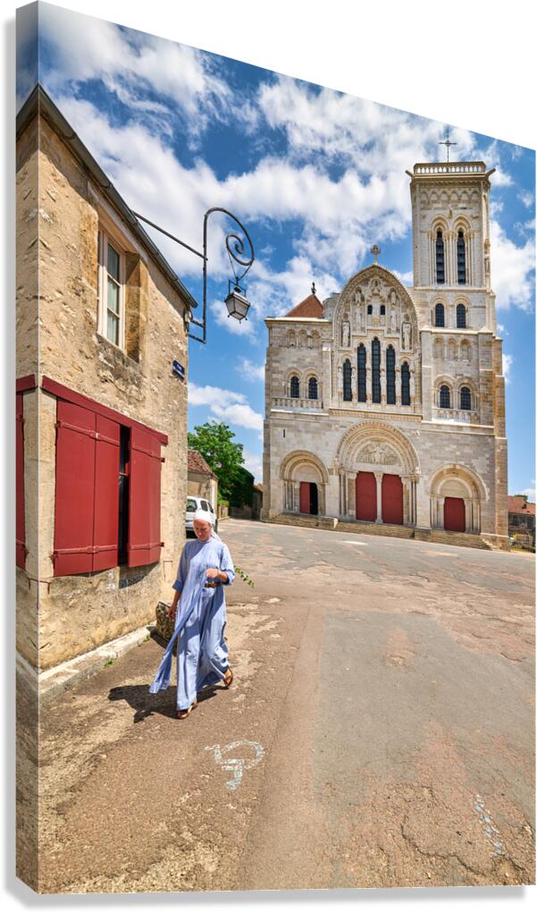 Nun walks by Vezelay Abbey in Bourgogne France during the day