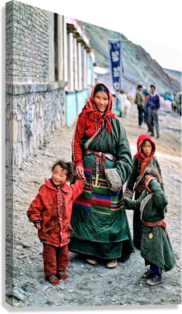 Smiling woman and children in traditional attire in Tibet