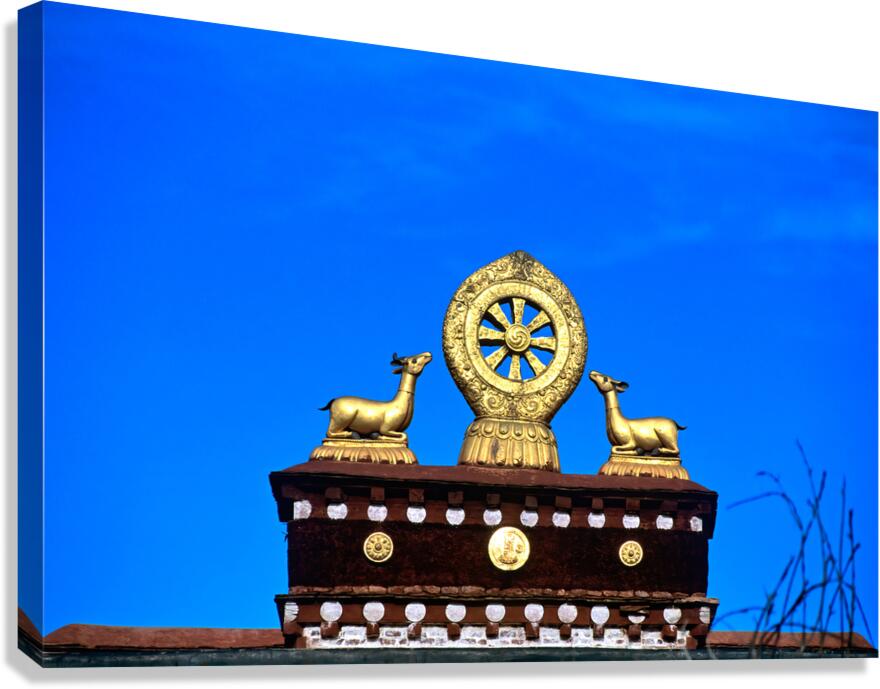 Golden Dharma wheel and deer statues on temple roof in Tibet
