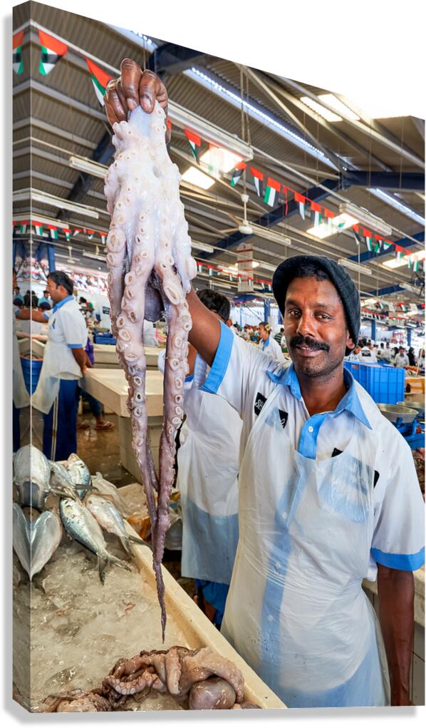 Vendor shows large octopus at fish market in Dubai