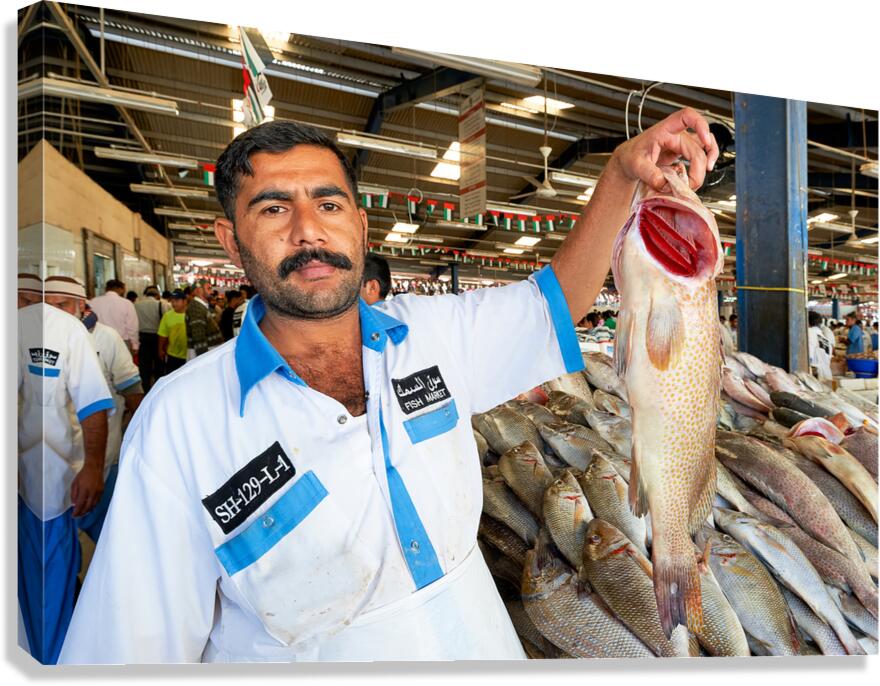 Fishmonger shows fresh catch at market in Dubai during busy day