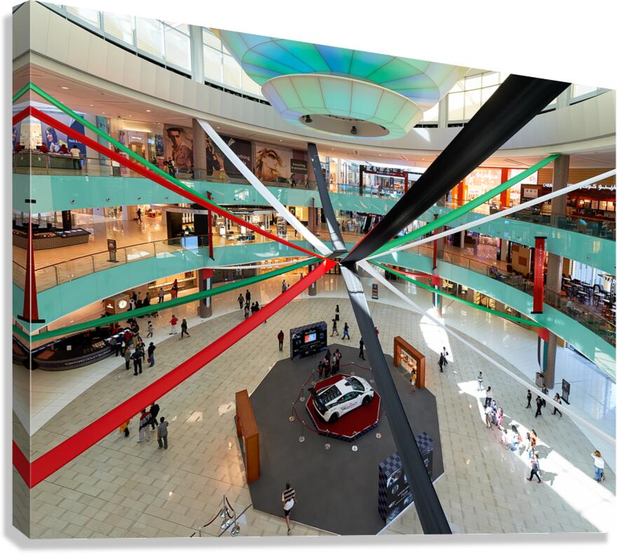 A busy mall in Dubai shows national flag ribbons and a sports ca